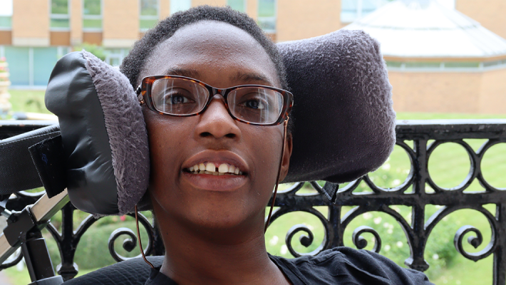 smiling pretty black women with glasses sitting in a wheelchair