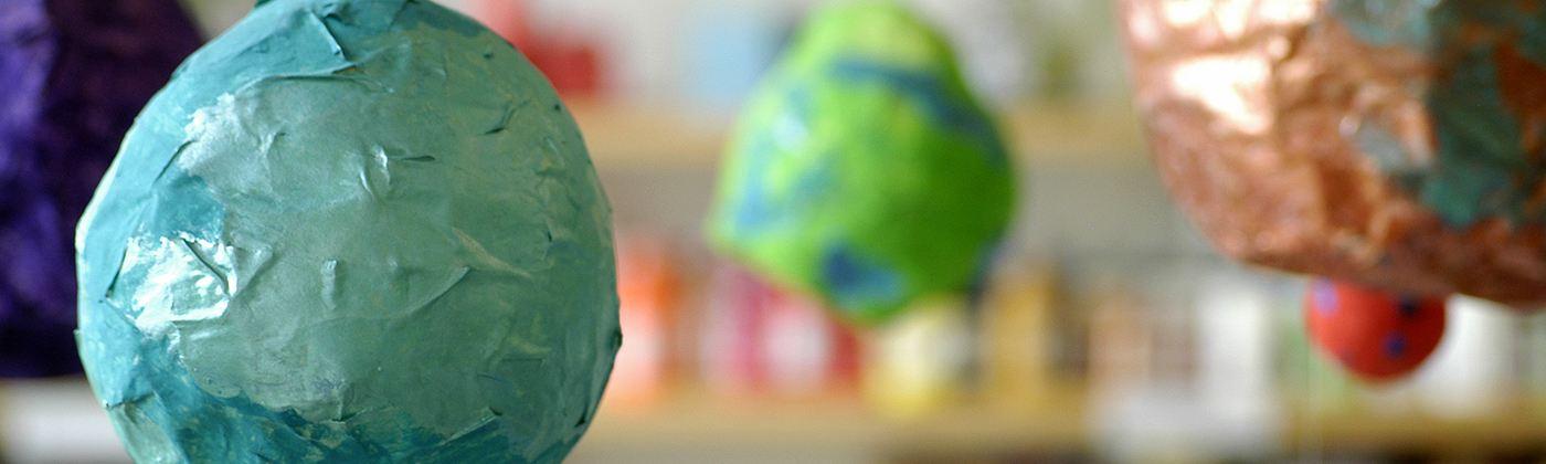 Hanging papier mache globes in the art room, which are an example of what we've done so far with funds raised.